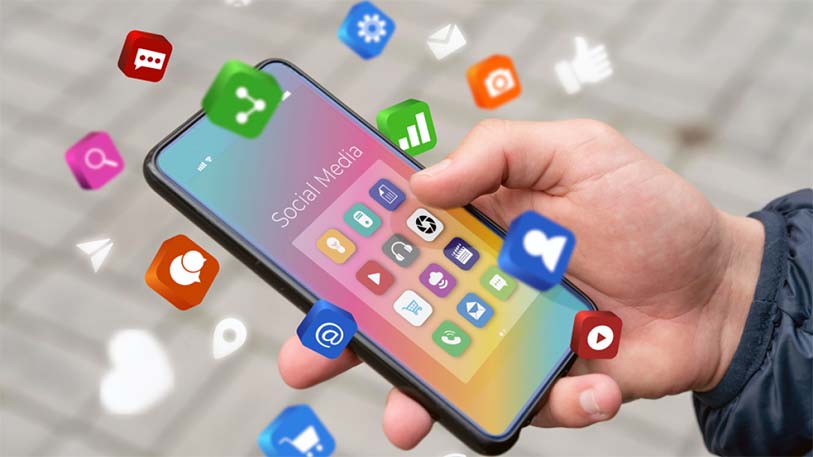 Hand holding a smartphone with floating social media icons – illustrating UI/UX differentiation strategy at EdroxCode, India.